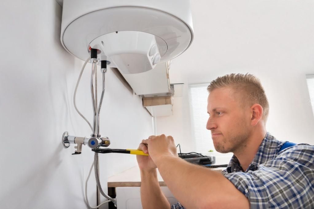 depositphotos-80939298-stock-photo-repairman-repairing-electric-boiler-transformed-1